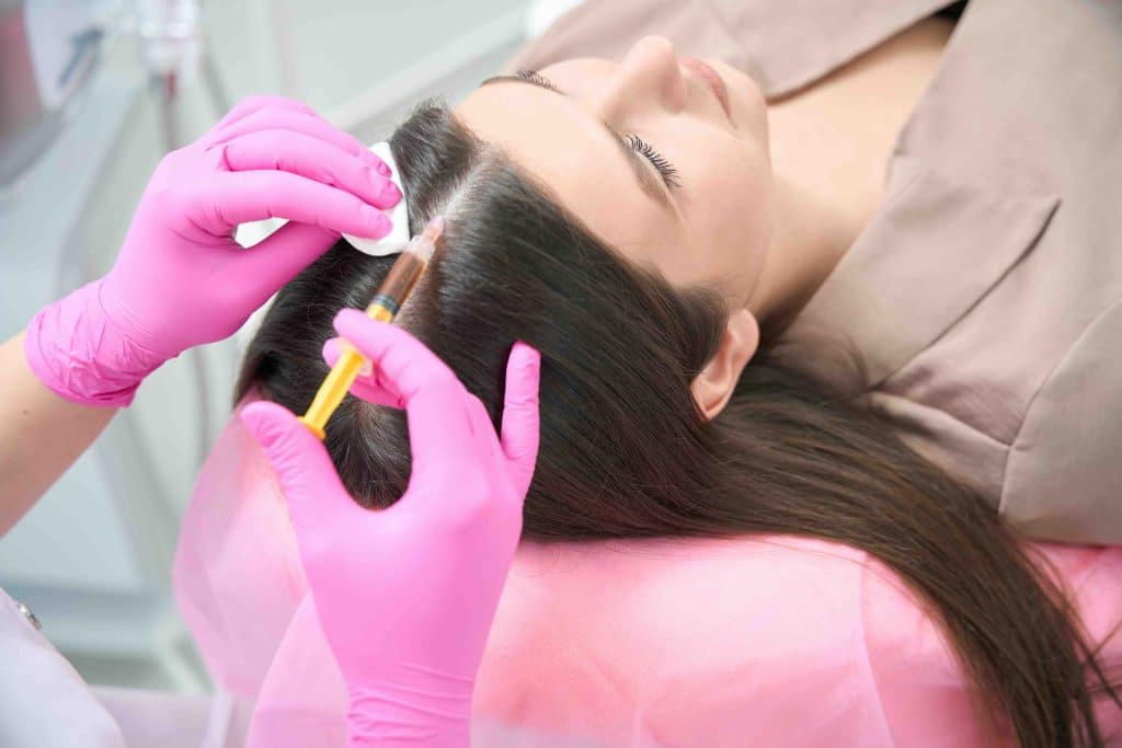 InjectCo nurse discussing PRF hair restoration candidacy with a patient at a Texas clinic