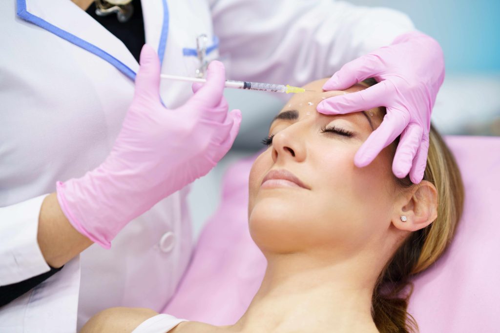 Nurse injector placing Botox in a patient forehead during a Dallas appointment