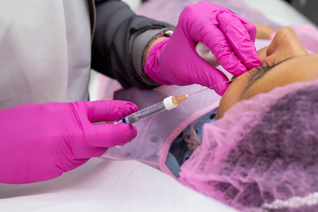 Licensed nurse injector performing a dermal filler treatment on a patient in a clinic