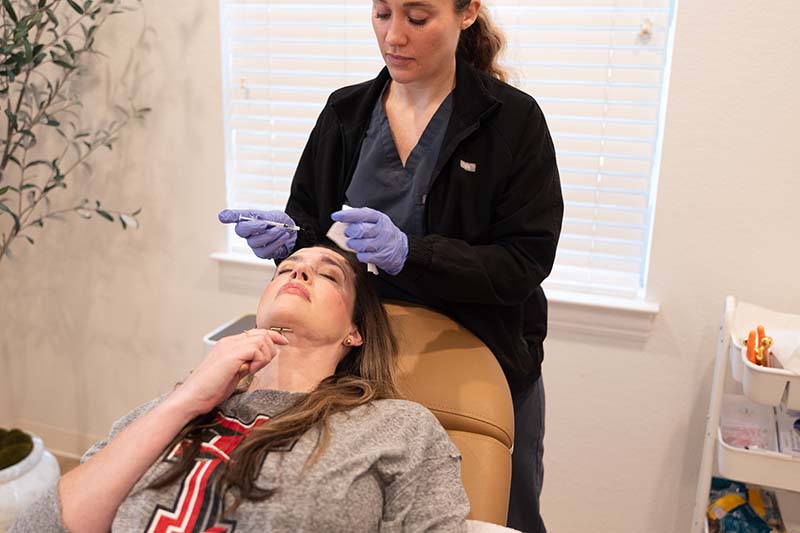 Licensed nurse injector administering Botox to a patient at the InjectCo med spa in Bedford, Texas
