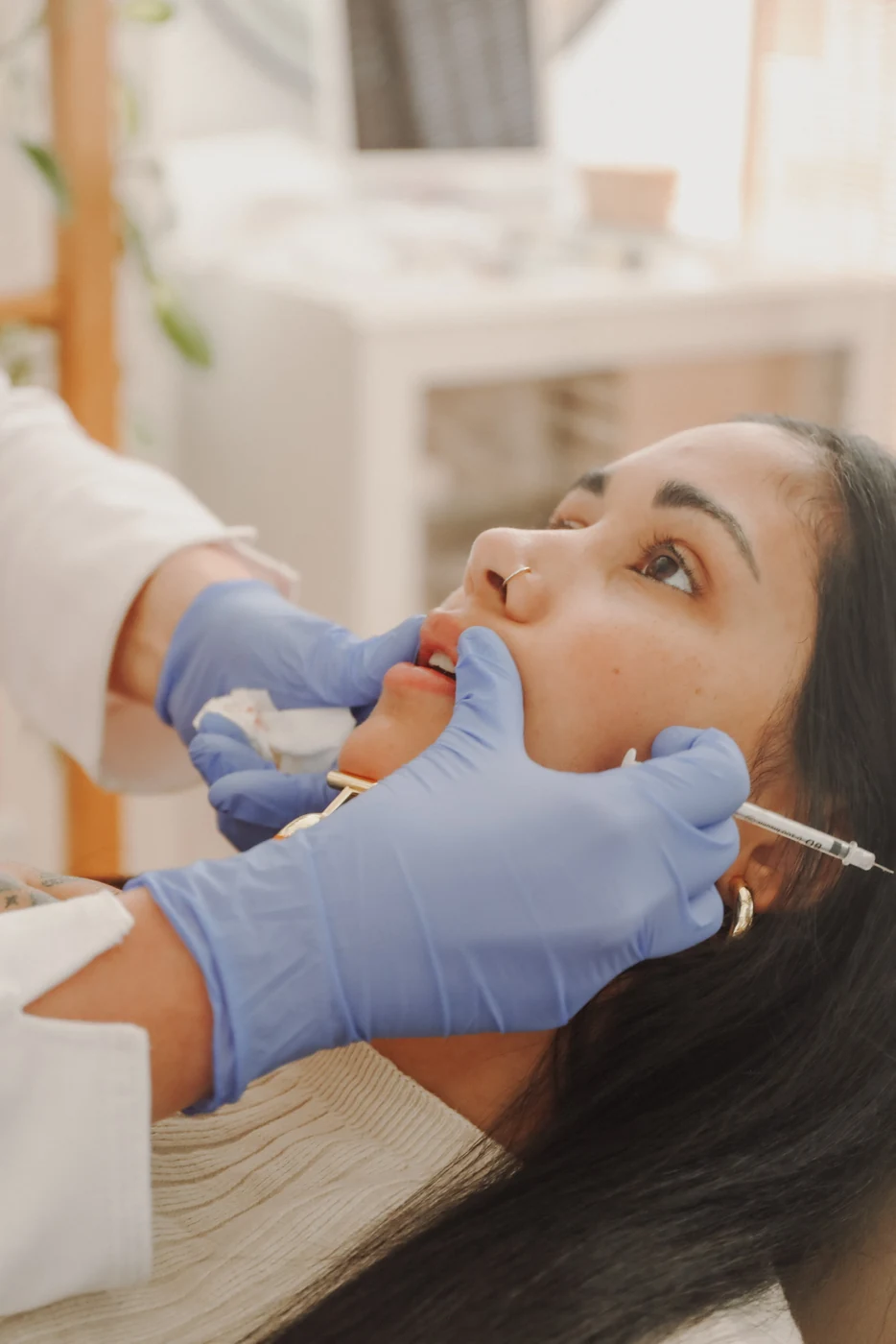 A nurse injecting dermal filler into a patient's upper lip