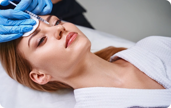 Smiling woman receiving a Botox injection, illustrating Botox pricing in Texas